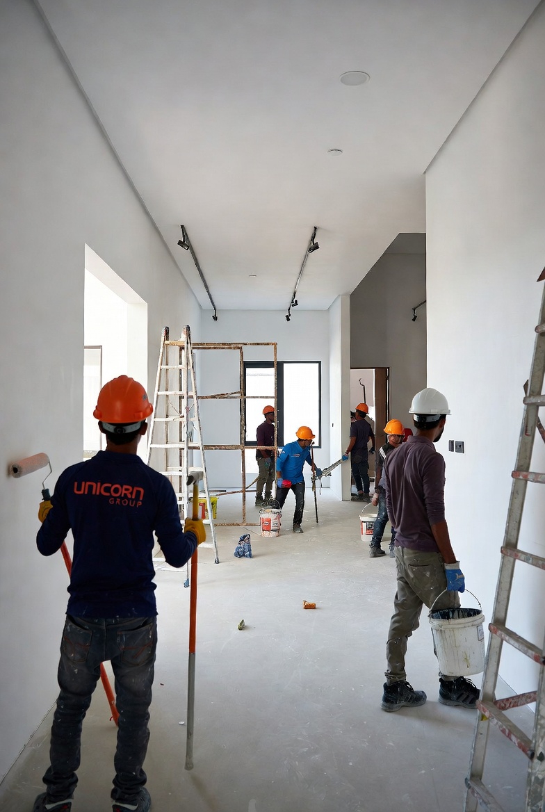 Painting crew preparing villa corridor walls